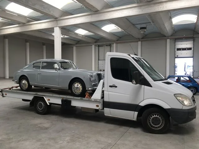 Lancia Aurelia d'epoca caricata su carro attrezzi Mercedes in capannone - servizio trasporto auto Imperia