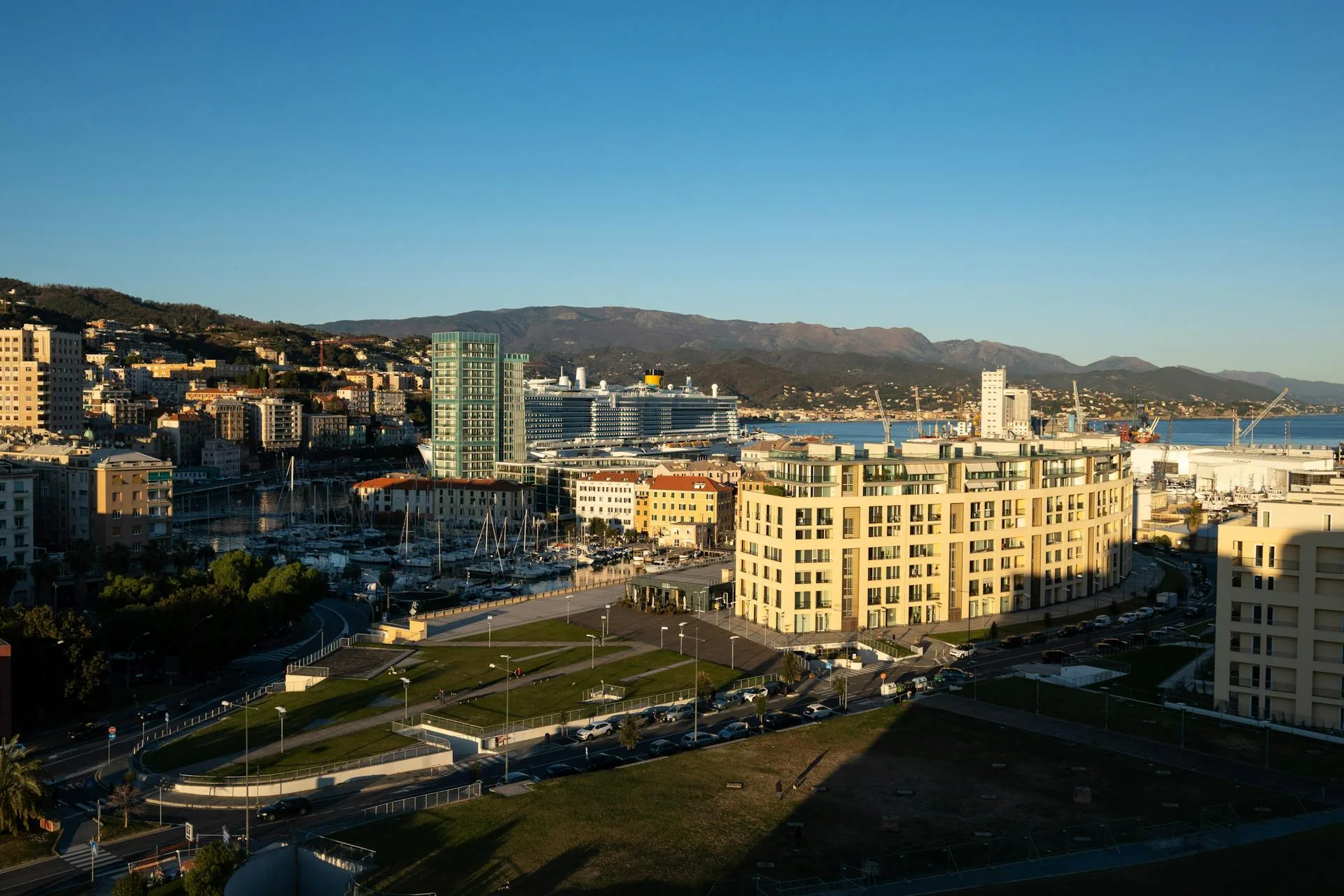 Il porto commerciale di Savona con una nave da crociera ormeggiata al tramonto